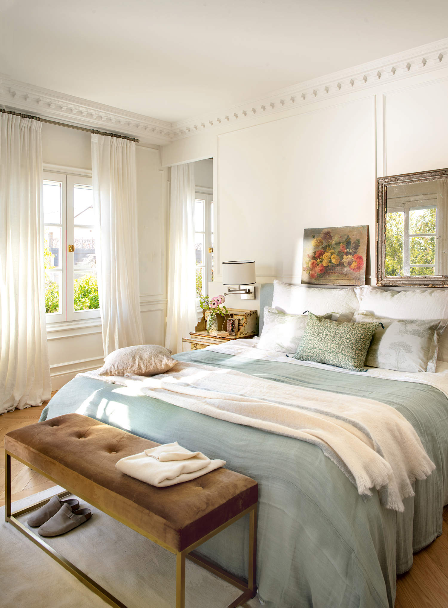 Dormitorio elegante con ropa de cama azul y pared con molduras
